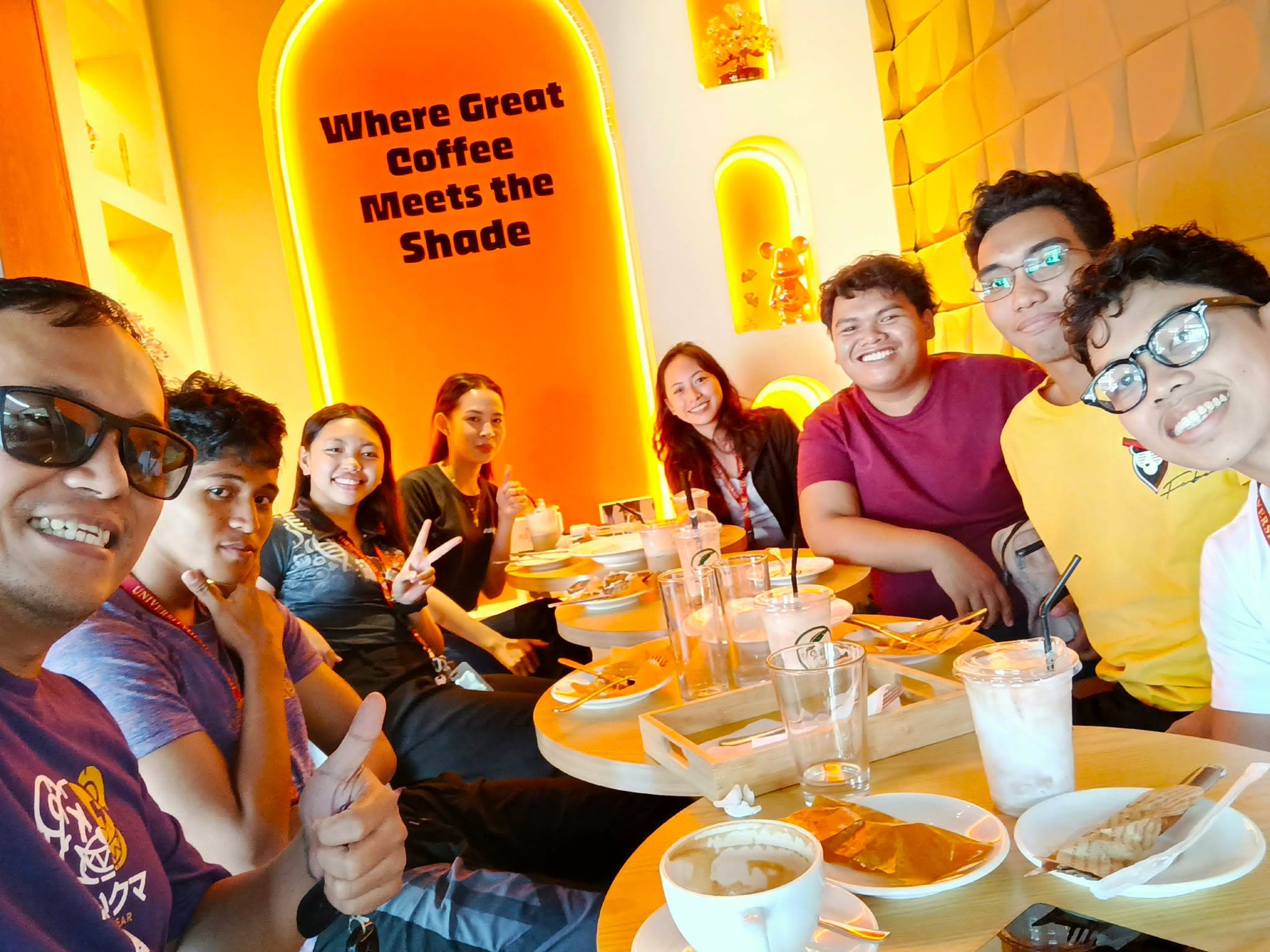 The PKC BIZOFT team gathered around a table at a coffee shop, smiling for a group selfie